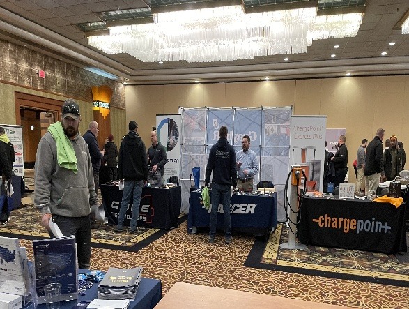 People clustered around tables in a vast room, participating in discussions and networking.