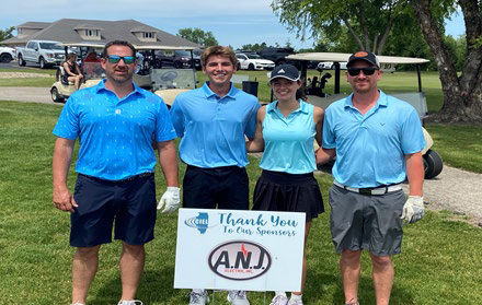 Four golfers in blue shirts posing behind a "Thank You To Our Sponsors" sign for A.N.J. Electric.